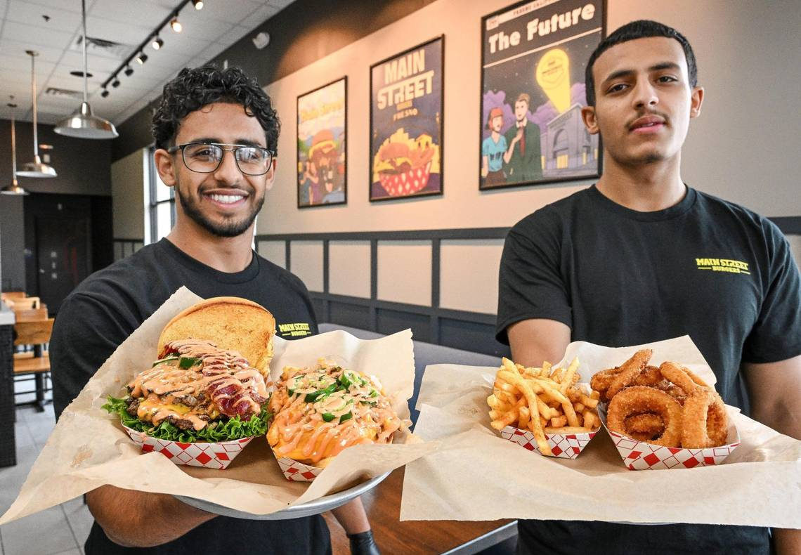 Khalid Abdulqawai, left, and his brother Omar hold up some of the bites available at their new restaurant, Main Street Burgers, in the Marketplace at El Paseo in northwest Fresno. CRAIG KOHLRUSS ckohlruss@fresnobee.com