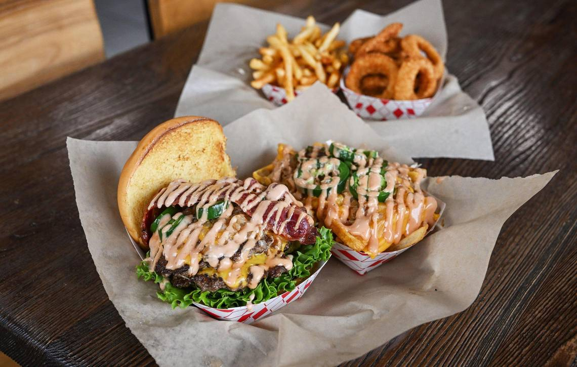 “The Main,” front left, Main Street Burgers’ signature burger, and street fries are pictured with onion rings and Cajun fries. CRAIG KOHLRUSS ckohlruss@fresnobee.com